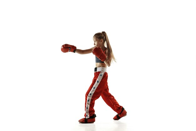 Young female kickboxing fighter training on white