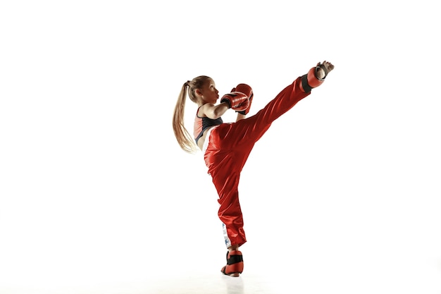 Free photo young female kickboxing fighter training on white