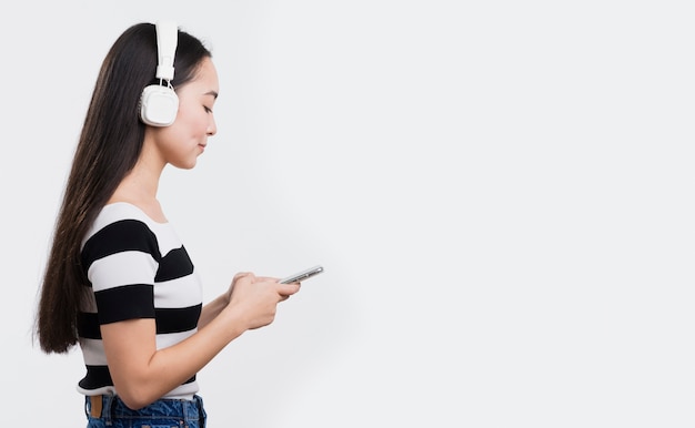 Young female listening music at headphones