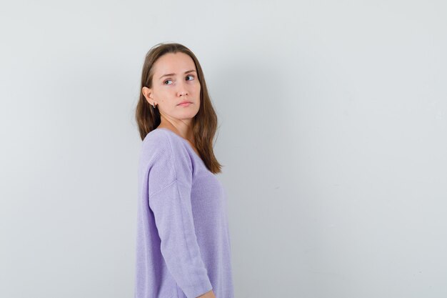 Young female looking back in lilac blouse and looking sensible. . space for text