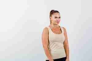 Free photo young female looking at camera in beige tank top and looking cute , front view.