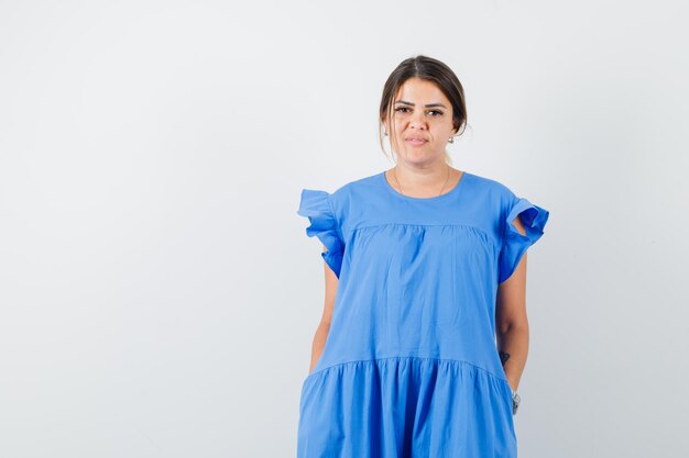 Young female looking at camera in blue dress and looking sensible