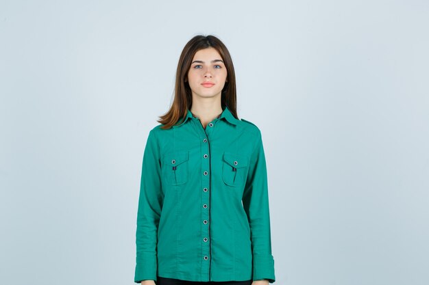 Young female looking at camera in green shirt and looking hopeful. front view.