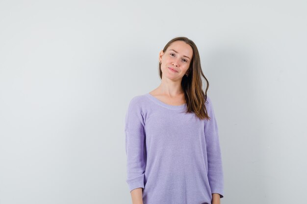 Young female looking at camera in lilac blouse and looking innocent. front view.