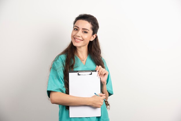 Young female medical employee holding medical records.