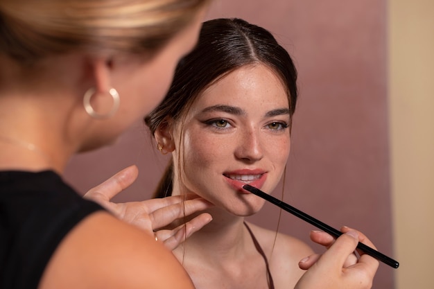 Young female model having her make up done by a professional artist