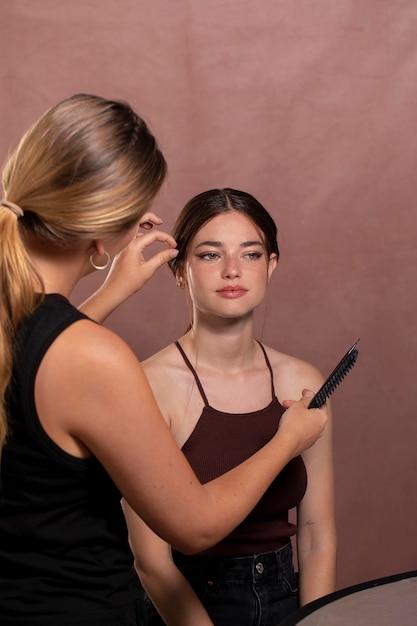 Free photo young female model having her make up done by a professional artist