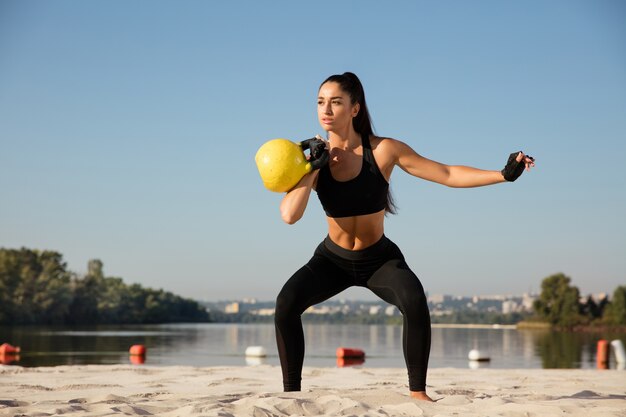 Young female model training outdoors in sunny day