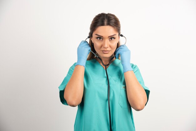 청진기를 착용하는 젊은 여성 간호사.