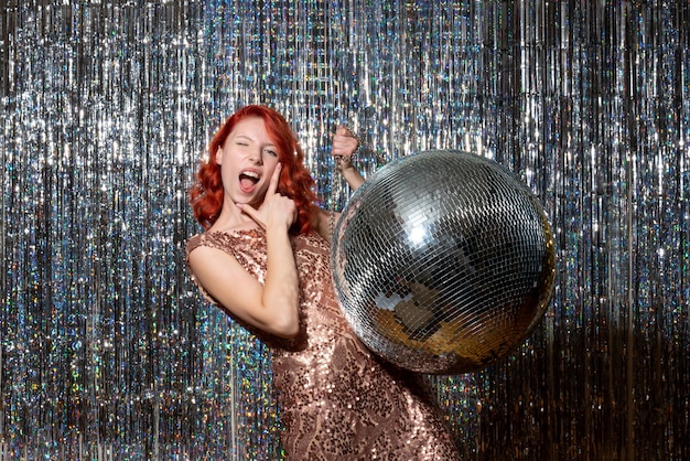 young female in party with disco ball on bright curtains