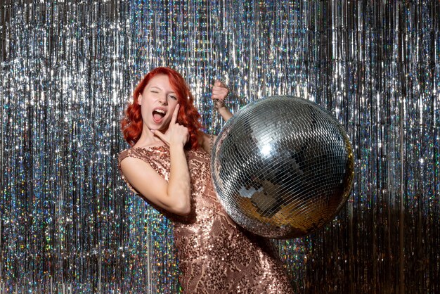 young female in party with disco ball on bright curtains