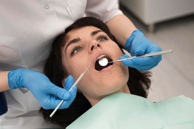 Foto gratuita giovane paziente femminile che ha procedura dentale all'ortodontista