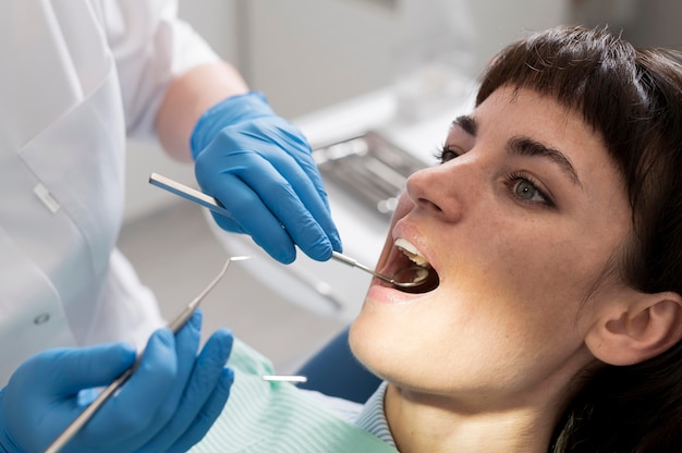 Foto gratuita giovane paziente femminile che ha procedura dentale all'ortodontista