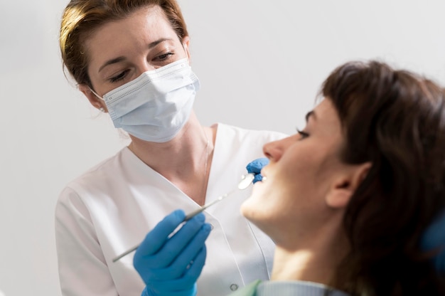 Foto gratuita giovane paziente femminile che ha procedura dentale all'ortodontista