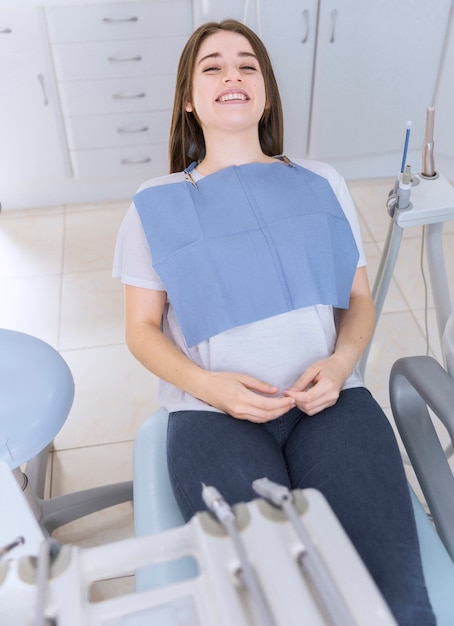 Young female patient sitting on chair in dental clinic