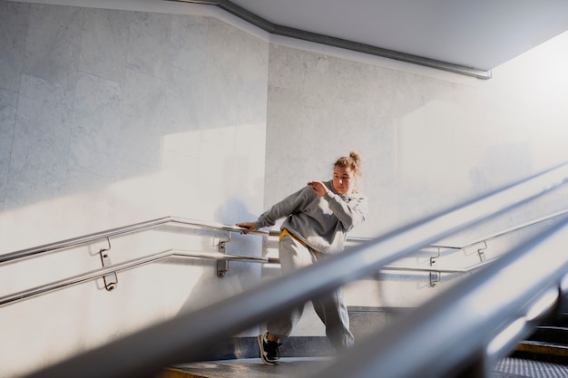 Free photo young female performer dancing in an abandoned building on stairs