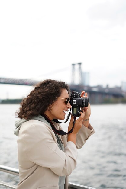 그녀의 카메라와 함께 도시를 탐험 하는 젊은 여성 사진 작가