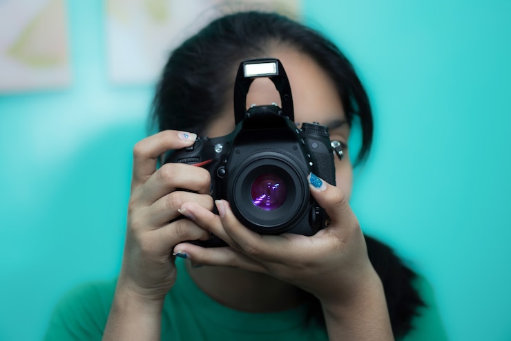 무료 Photo dslr 카메라로 사진을 찍는 젊은 여성 사진 작가