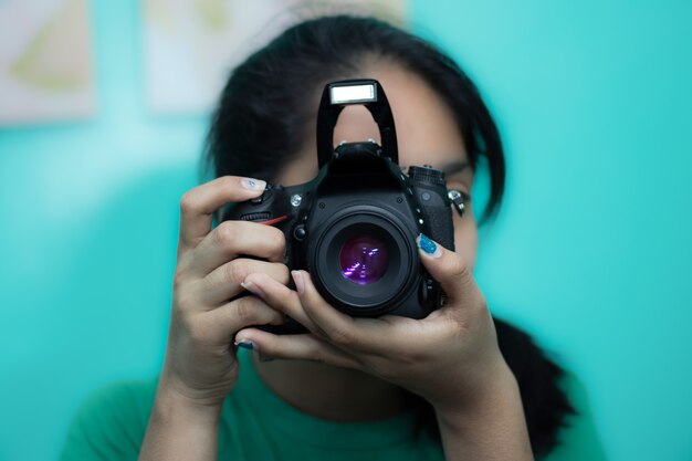 デジタル一眼レフカメラで写真を撮る若い女性写真家