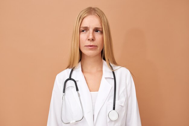 Молодая женщина-врач с прямыми светлыми волосами и стетоскопом на шее
