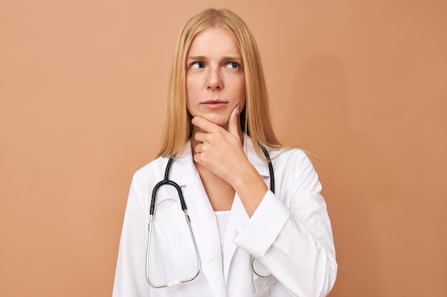 Молодая женщина-врач с прямыми светлыми волосами и стетоскопом на шее
