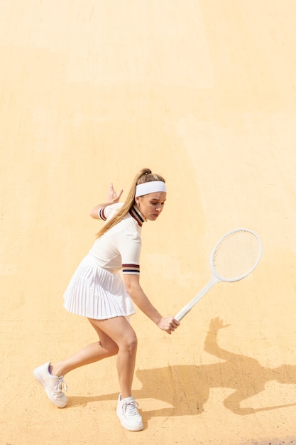 フィールドでテニスをしている若い女性