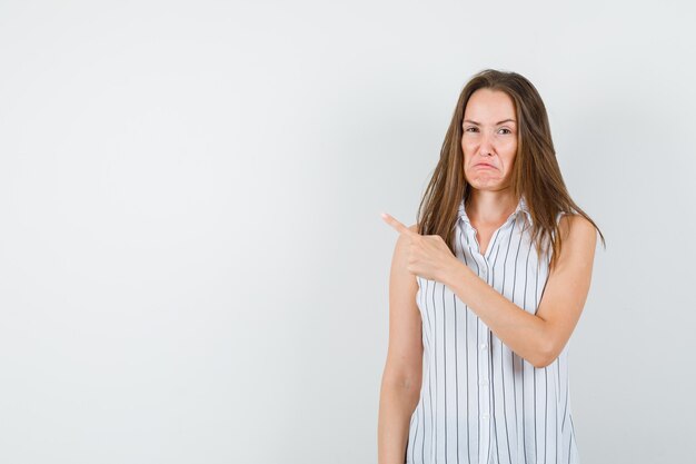 若い女性がTシャツを着て、悲しそうに見えます。正面図。