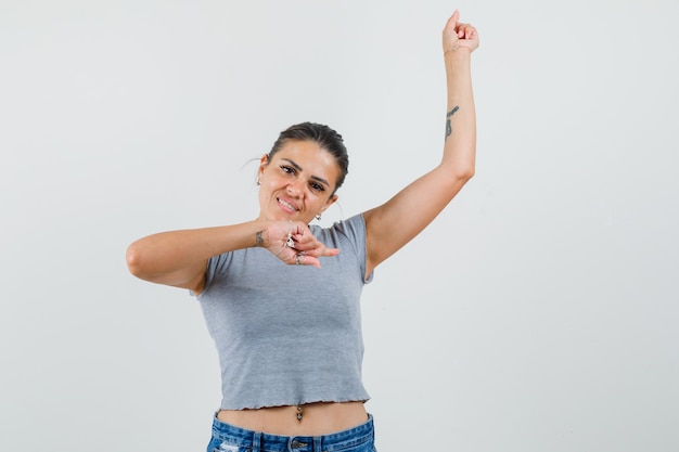 Free photo young female pointing to the side with finger up in t-shirt, shorts and looking cute.