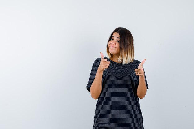 Young female in polo dress pointing at camera and looking confident , front view.