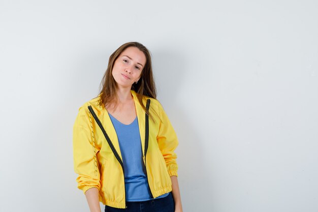 Young female posing while looking at camera in t-shirt, jacket and looking glamorous, front view.