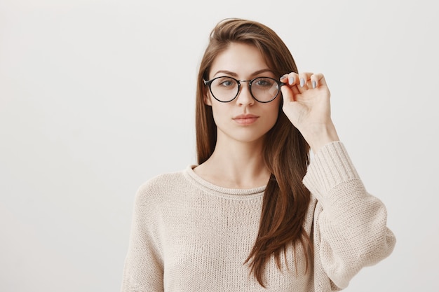 Free photo young female put on glasses, looking determined