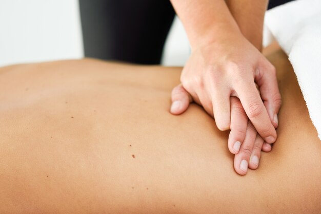 Young female receiving a relaxing back massage in a spa center. 