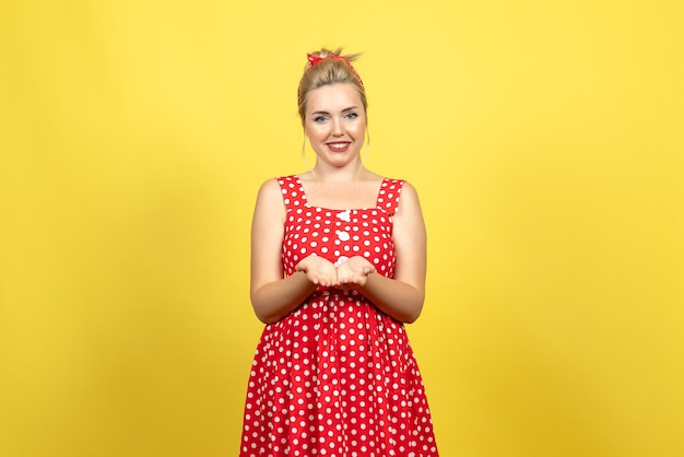 노란색에 웃 고 빨간색 폴카 도트 드레스에 젊은 여성