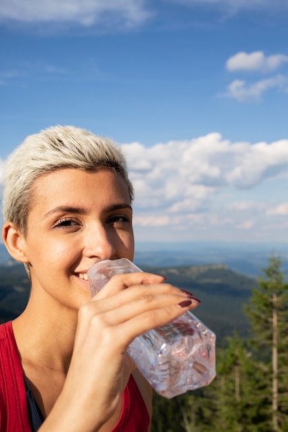 Young female runner drinking water