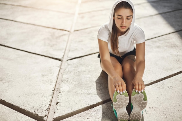 都市環境で彼女の人生の実行を開始する前にストレッチする若い女性ランナースポーツは私たちを強くします