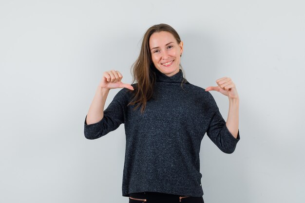 Young female in shirt pointing at herself and looking proud 