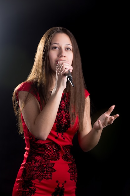 Free photo young female singer in red dress