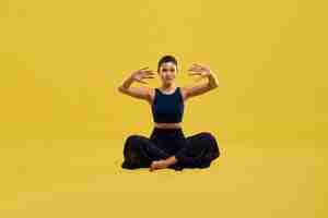 Free photo young female sitting on floor doing yoga