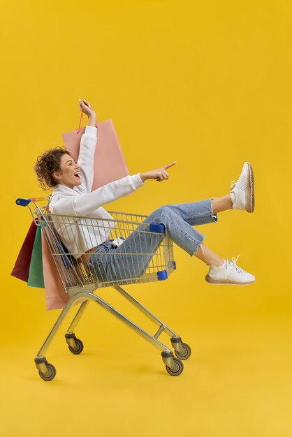 Young female sitting in shopping cart