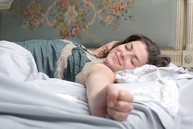 Giovane donna che dorme pacificamente nel letto la mattina