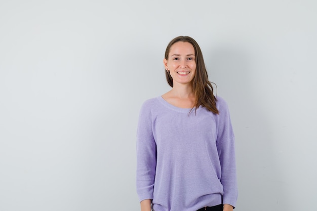 Young female smiling in lilac blouse and looking cheery. front view. space for text