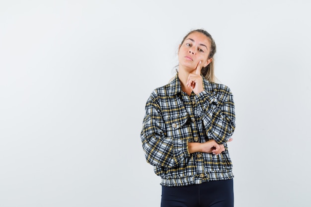 Young female standing in thinking pose in shirt, shorts and looking cute. front view.