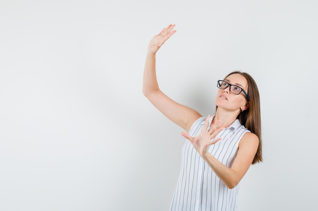 Young female standing with outstretched hands for greeting in t-shirt front view.