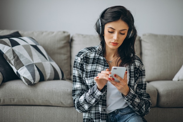 Musica d'ascolto della giovane studentessa tramite il telefono sulle cuffie