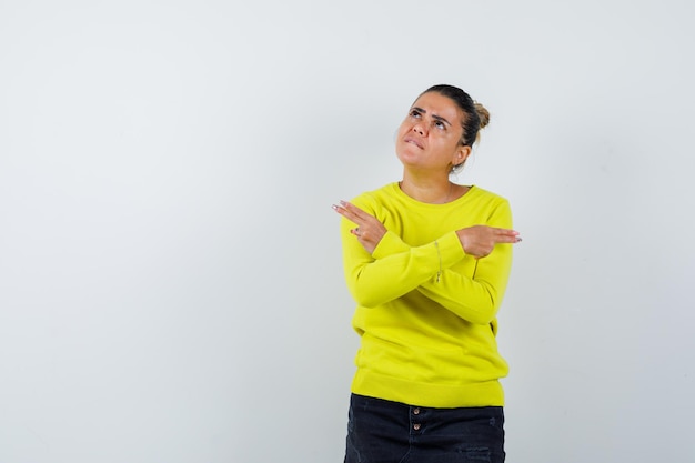 Free photo young female in sweater, denim skirt showing gun gesture and looking spiteful