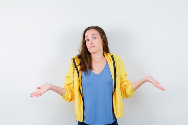 Foto gratuita giovane donna in t-shirt, giacca che mostra un gesto impotente e sembra confusa, vista frontale.