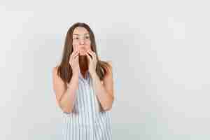 Free photo young female in t-shirt pulling down face skin in aggressive manner and looking highly strung , front view.