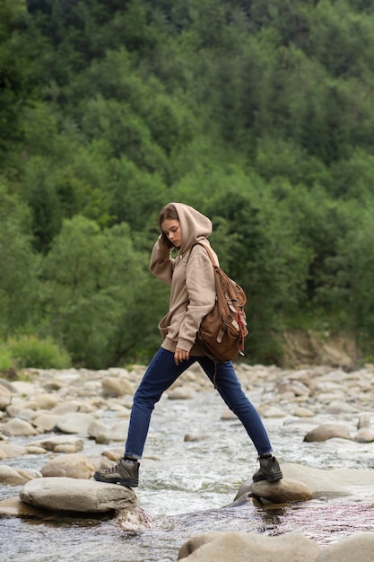 Free photo young female traveler enjoying rural surroundings