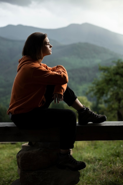 Free photo young female traveler enjoying rural surroundings