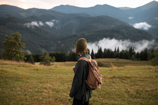 Free photo young female traveler enjoying rural surroundings